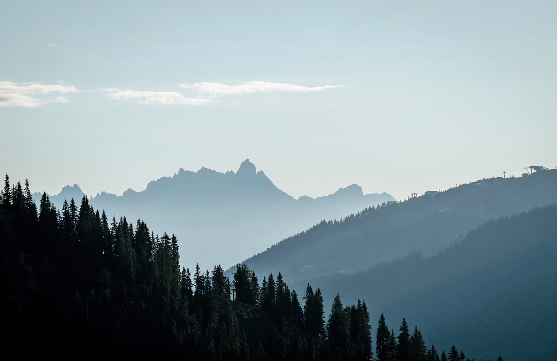 Berglandschaft mit Wald und Almwiesen in Kleinarl und der Bergbahn im Hintergrund
