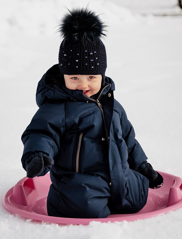 Kinder auf einem Rutschblatt beim Winterurlaub im Aparthotel JoAnn